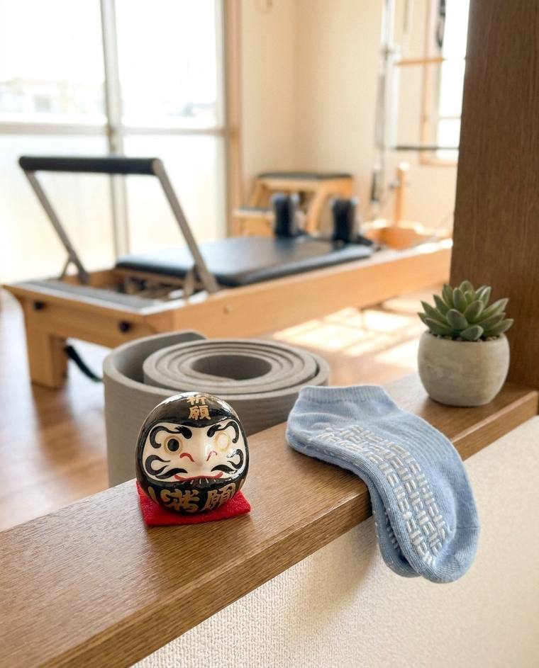 A black one-eyed Daruma on a windowsill in Hannah's kitchen