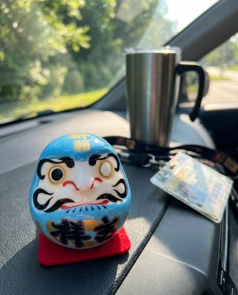 The one-eyed blue Daruma on the shelf above the coat hook where the suitcase used to sit