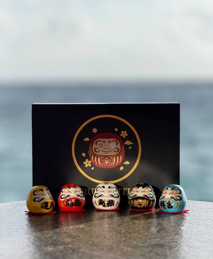 The five ceramic Daruma of the set lined up by color