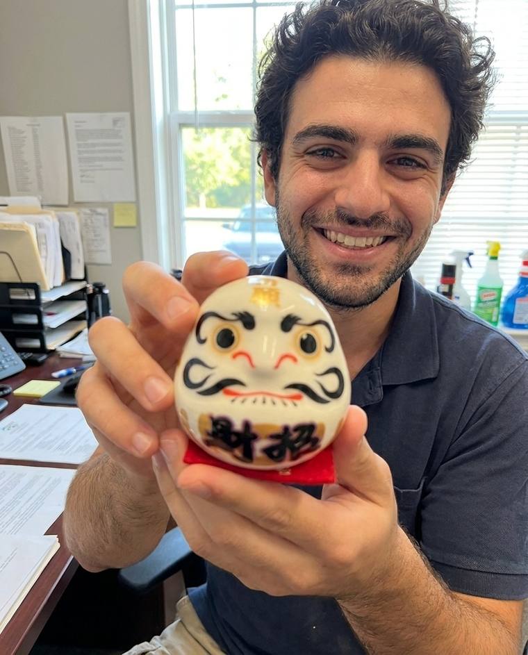 Jack filling in the second eye of the white Daruma at his kitchen table