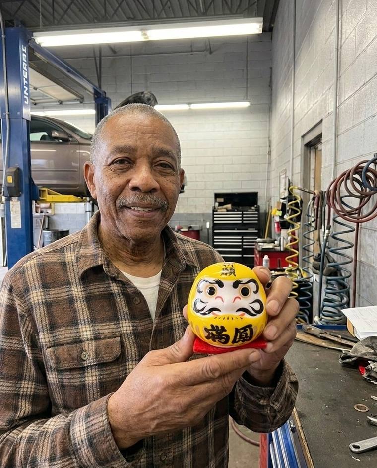 Walter filling in the second eye of the yellow Daruma at his kitchen table