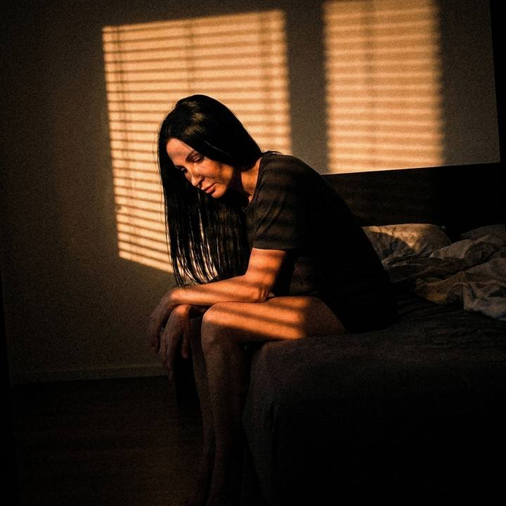 Elena Novak sitting on the edge of her bed in the early evening