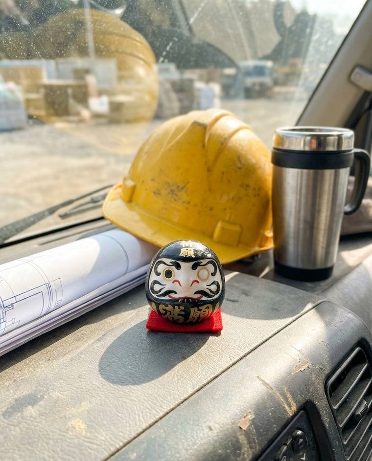 A one-eyed black Daruma on the windowsill above Max's kitchen sink