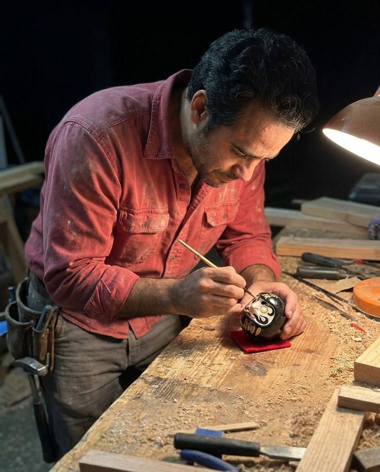 Chris filling the first eye of a black Daruma with a framing pencil